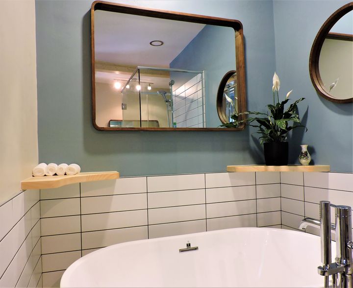 Bathroom with a wood mirror frame and shelves