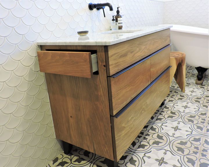 Three-drawer wooden vanity with a white basin