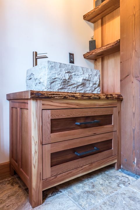 Wooden vanity with a carved stone basin
